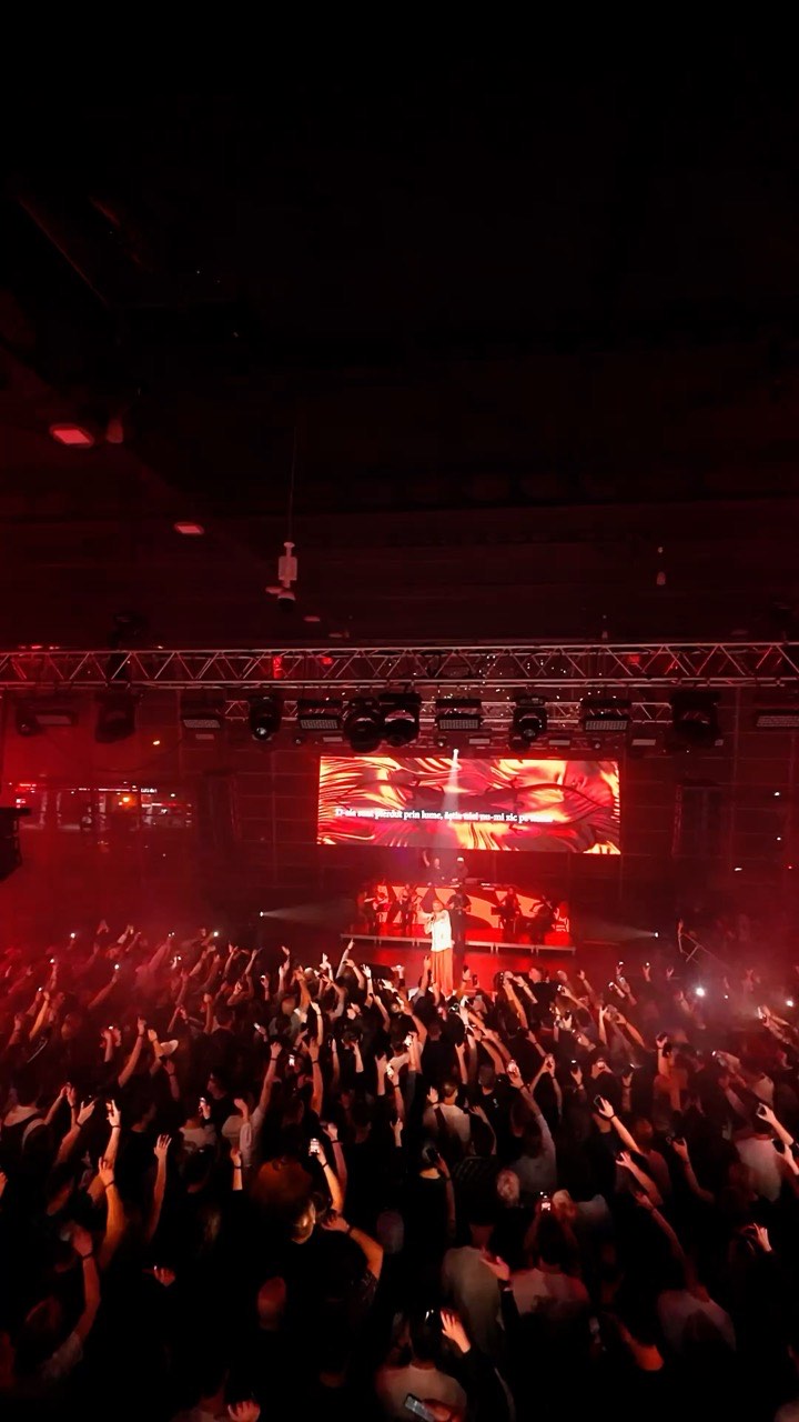 Public la un concert, cu scena luminată în roșu
